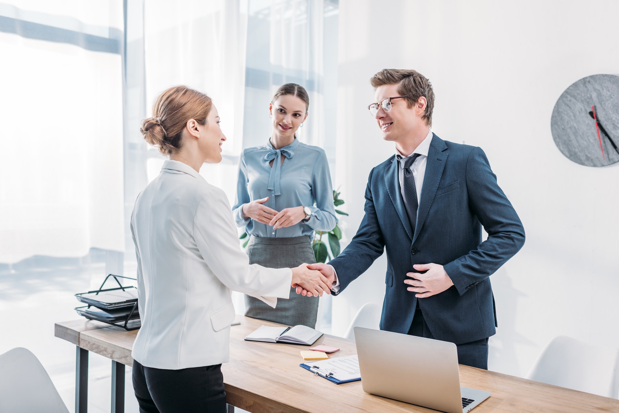Elementor #56413 26 cheerful recruiter shaking hands with woman near colleague in office 1